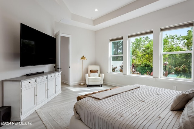 bedroom with multiple windows and light hardwood / wood-style flooring