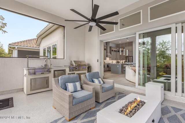 view of patio / terrace with a fire pit, ceiling fan, and area for grilling