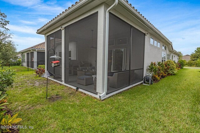 view of side of property with a sunroom and a yard