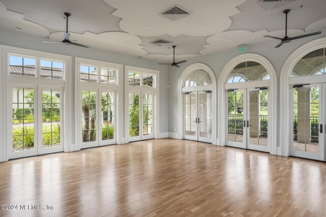 unfurnished sunroom featuring ceiling fan and french doors