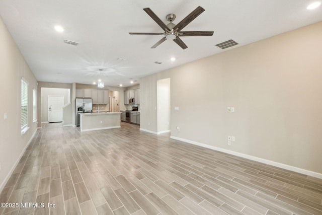 unfurnished living room featuring ceiling fan and light hardwood / wood-style flooring