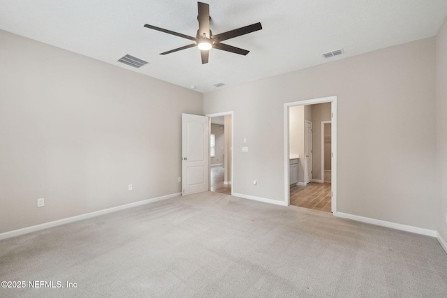 unfurnished bedroom with ensuite bath, light colored carpet, and ceiling fan