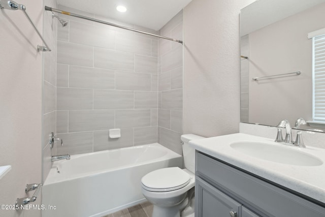 full bathroom with tiled shower / bath, vanity, and toilet