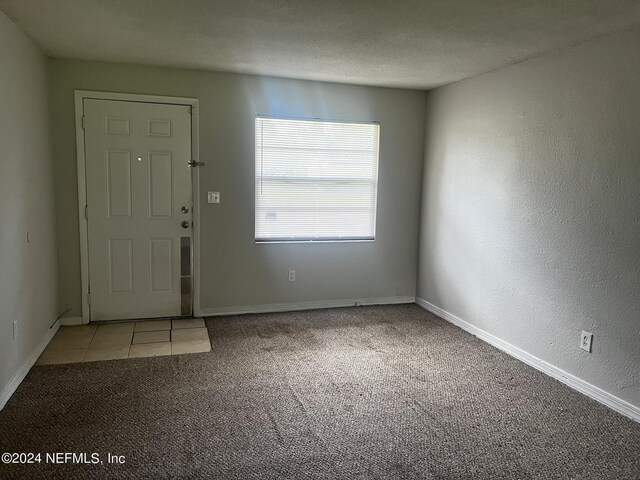 carpeted foyer featuring a textured ceiling