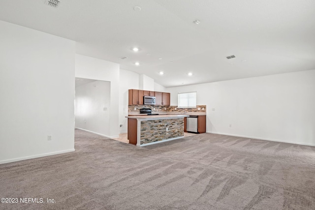 kitchen with stainless steel appliances, a kitchen island, decorative backsplash, lofted ceiling, and light colored carpet