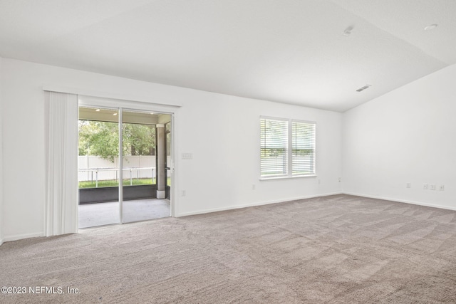 carpeted spare room featuring lofted ceiling