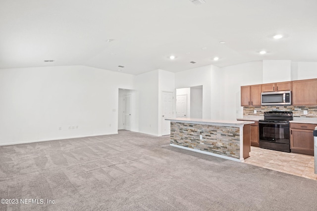 kitchen with black / electric stove, vaulted ceiling, a kitchen island, light carpet, and backsplash