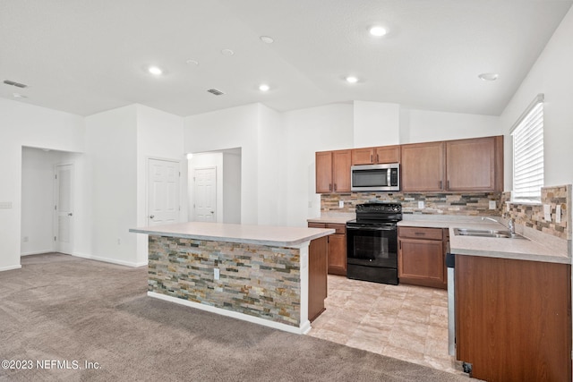 kitchen featuring black electric range oven, a kitchen island, sink, and light colored carpet