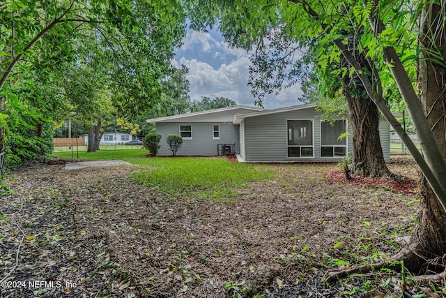 back of house featuring a lawn and a sunroom