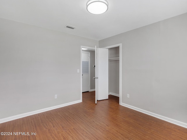 unfurnished bedroom with hardwood / wood-style flooring and a closet