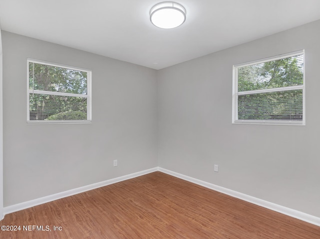 spare room with hardwood / wood-style flooring and plenty of natural light