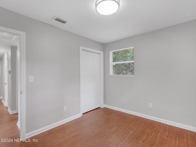 unfurnished bedroom featuring a closet and light hardwood / wood-style floors