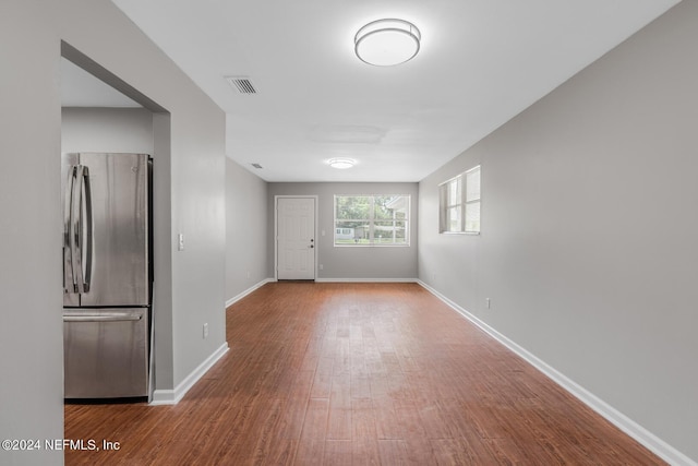 empty room featuring visible vents, baseboards, and wood finished floors