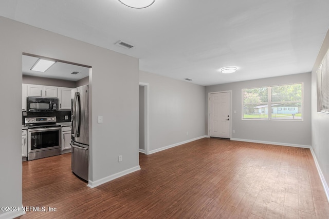 interior space featuring visible vents, white cabinetry, stainless steel appliances, baseboards, and dark wood-style flooring