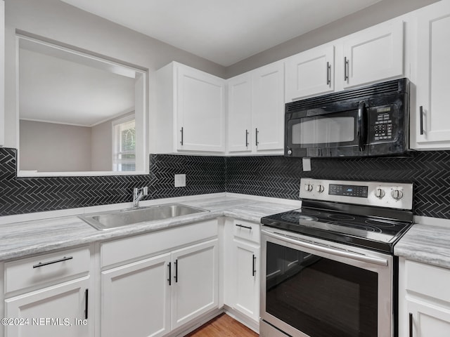 kitchen featuring stainless steel electric range, light stone counters, white cabinetry, and sink