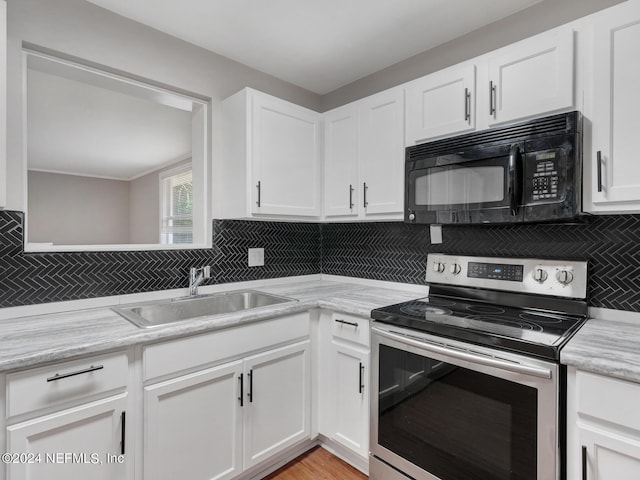 kitchen with a sink, backsplash, stainless steel electric stove, white cabinets, and black microwave