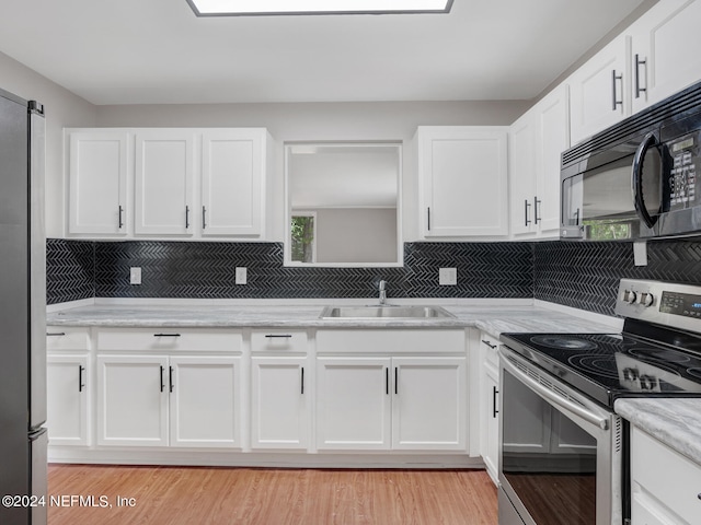 kitchen featuring white cabinets, appliances with stainless steel finishes, light hardwood / wood-style floors, and sink