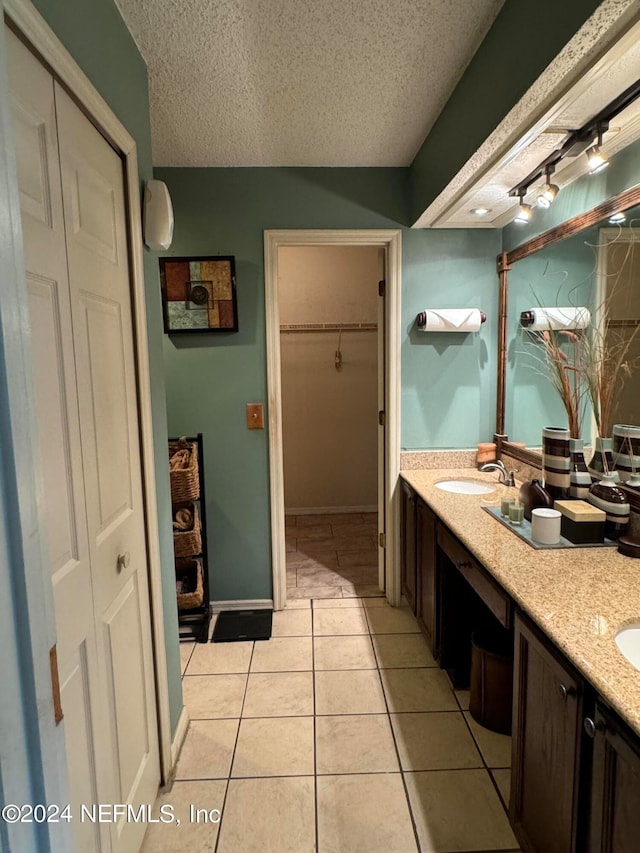 bathroom featuring tile patterned flooring, a textured ceiling, and vanity