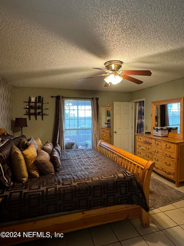 bedroom featuring tile patterned flooring, ceiling fan, and a textured ceiling