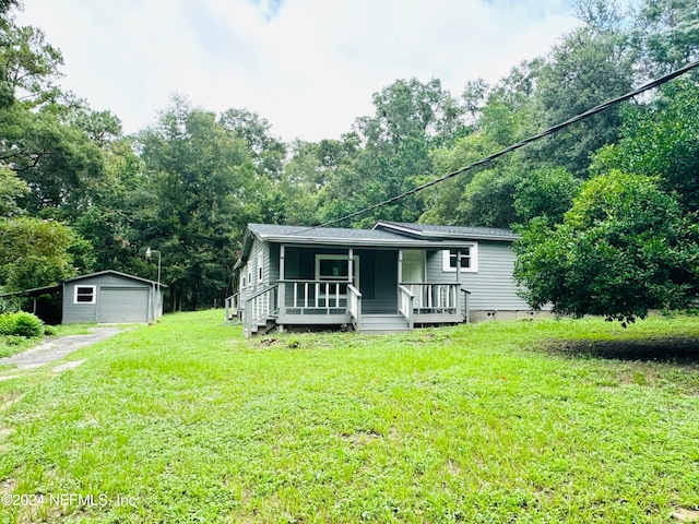 view of front of house featuring a porch, an outdoor structure, a garage, and a front yard