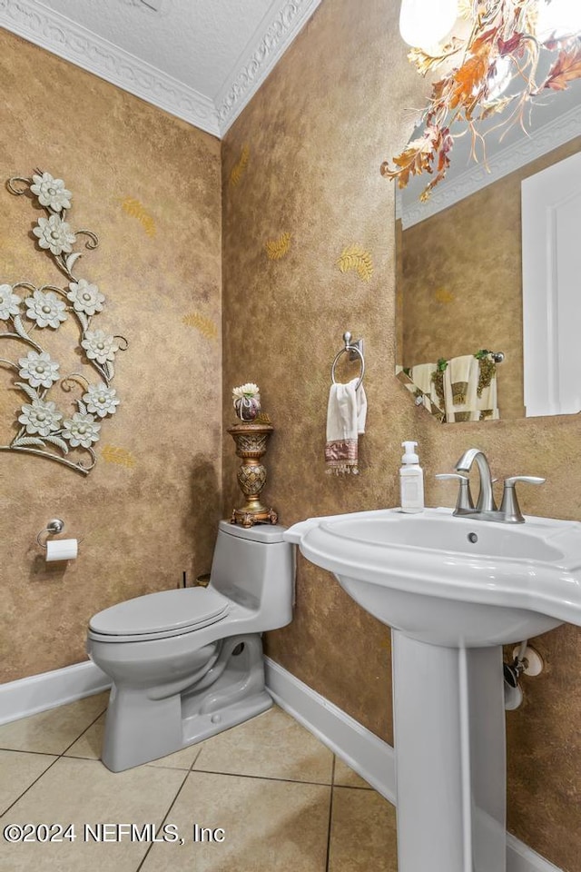 bathroom featuring toilet, ornamental molding, sink, a textured ceiling, and tile patterned flooring