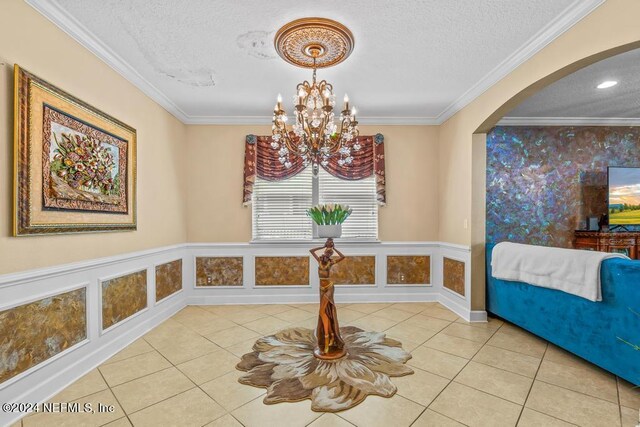 dining area with a textured ceiling, tile patterned floors, and crown molding