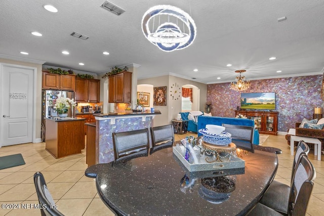 tiled dining space with an inviting chandelier, crown molding, and a textured ceiling