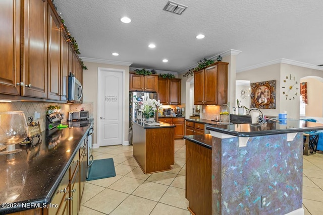 kitchen with stainless steel appliances, a breakfast bar, ornamental molding, and a kitchen island