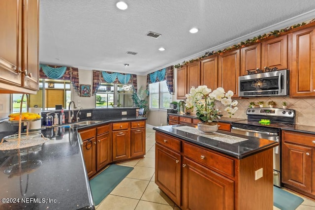 kitchen featuring a kitchen island, stainless steel appliances, a textured ceiling, crown molding, and sink