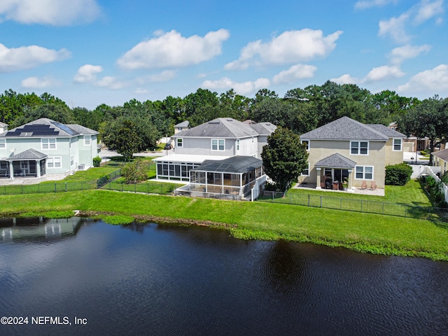 rear view of property with a water view and a yard