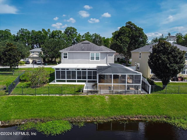 back of property with a lanai, a yard, and a water view