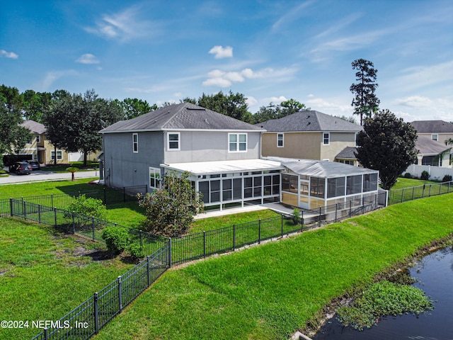 rear view of house featuring a water view and a yard