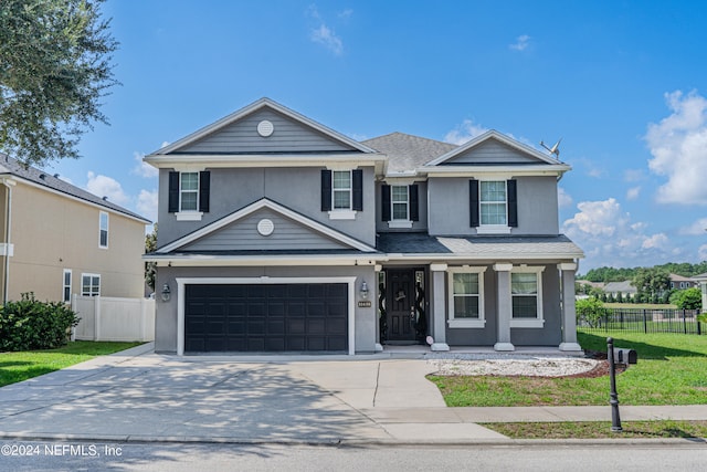 front of property with a garage, covered porch, and a front lawn