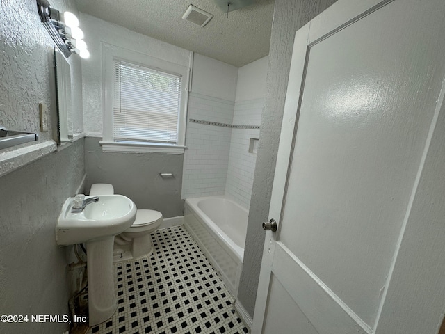 bathroom featuring toilet and a textured ceiling