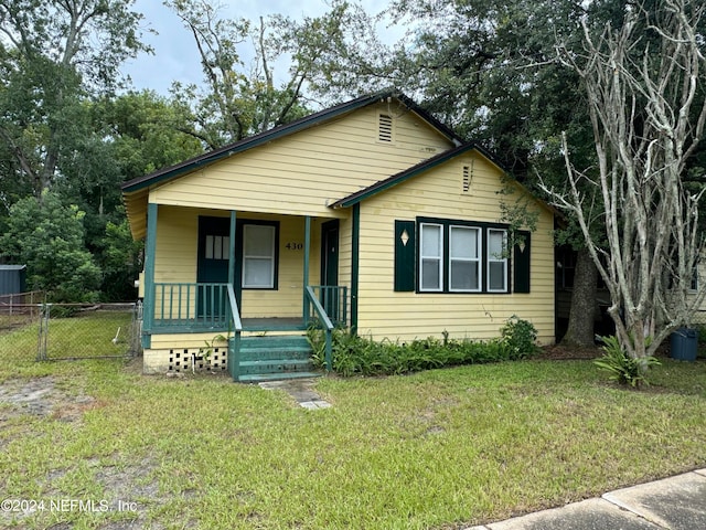 bungalow-style home featuring a front lawn and covered porch