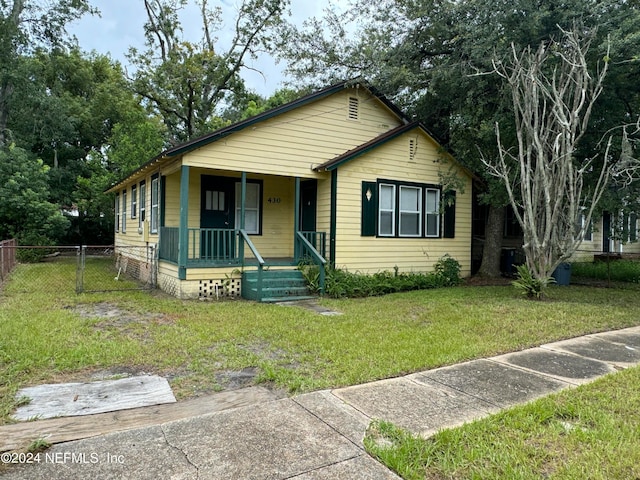 view of front of house featuring covered porch and a front yard