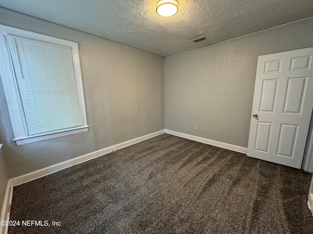 carpeted spare room featuring a textured ceiling