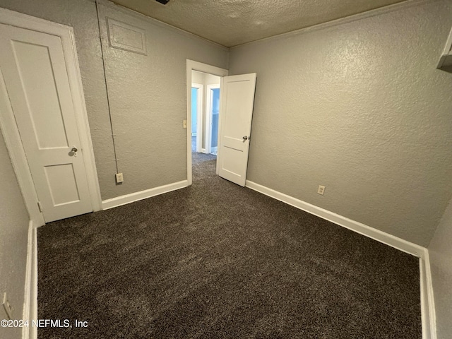 unfurnished bedroom featuring a textured ceiling and carpet floors