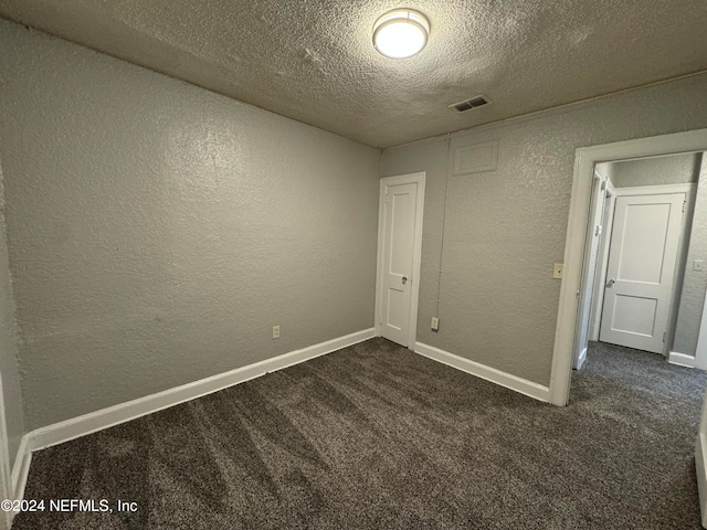 unfurnished bedroom with a textured ceiling and carpet floors