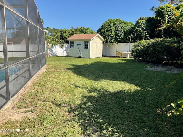 view of yard featuring a shed and glass enclosure