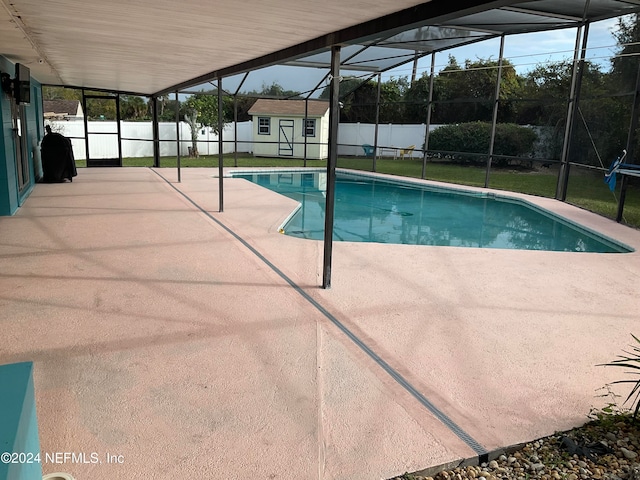 view of pool with a storage shed, a patio area, and a lanai