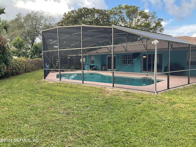 rear view of house featuring a yard, a patio, and a lanai