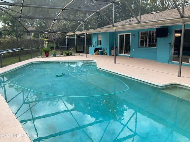 view of pool with a patio and glass enclosure