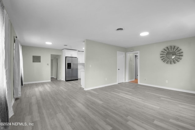 unfurnished living room featuring light wood-type flooring, visible vents, baseboards, and recessed lighting