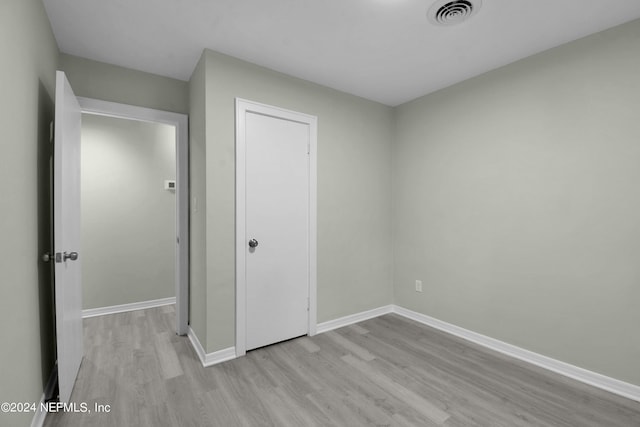 unfurnished bedroom with a closet and light hardwood / wood-style floors