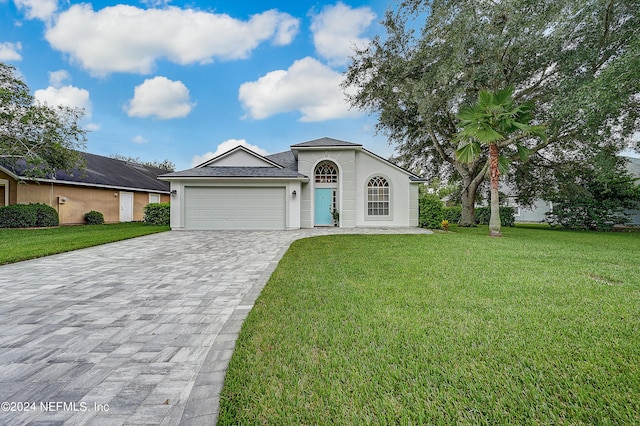 ranch-style home featuring a garage and a front lawn