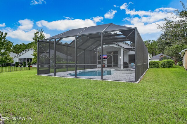 back of house featuring a yard, a patio, and glass enclosure