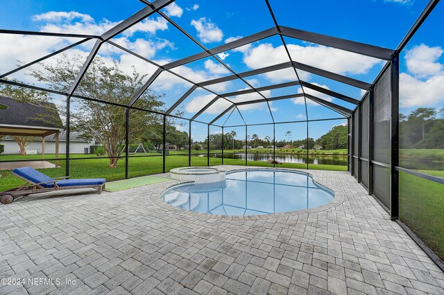 view of swimming pool with glass enclosure, a water view, a yard, and a patio area