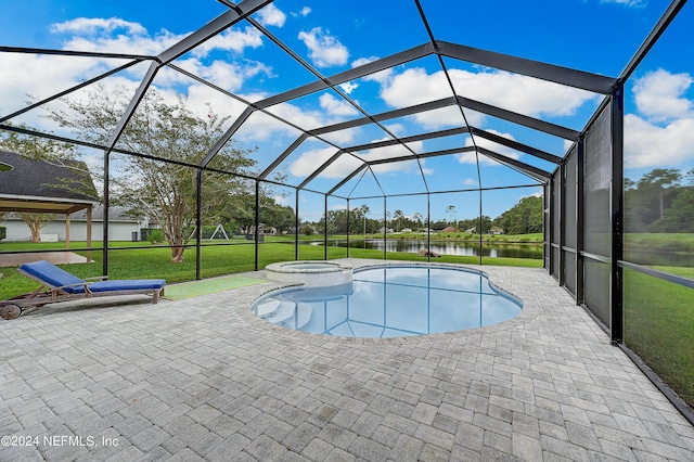 view of swimming pool featuring a patio, a yard, a water view, and a pool with connected hot tub