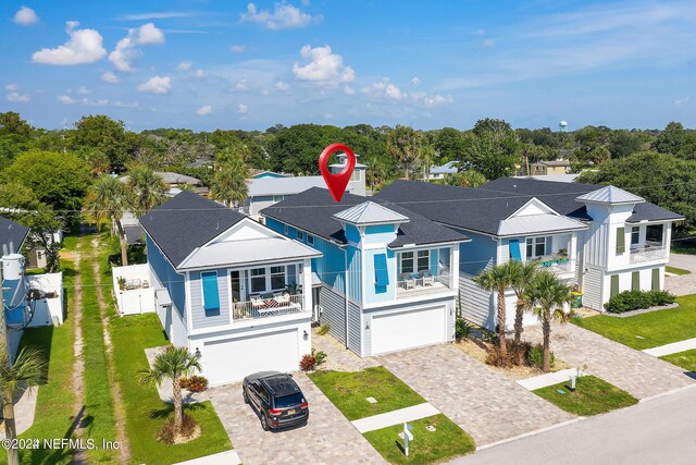 view of front of home with a balcony, a garage, and a front yard